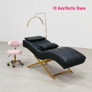 Close-up of premium pink PU leather upholstery and gold frame detailing on eyelash extension bed